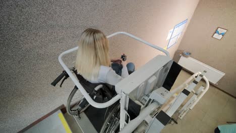 una niña en silla de ruedas sube las escaleras sin esfuerzo usando un ascensor de escaleras.