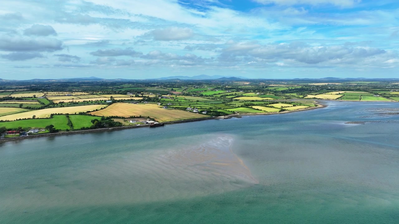 Irlanda, luoghi epici: drone che vola verso la costa di Wexford a Bannow Bay, mari blu e un mosaico di fertili terreni agricoli, la bellezza dell'Irlanda.
