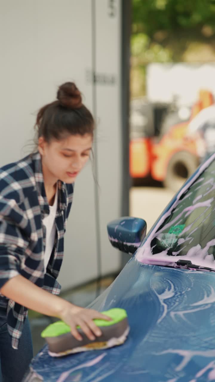 una mujer lavando un coche.