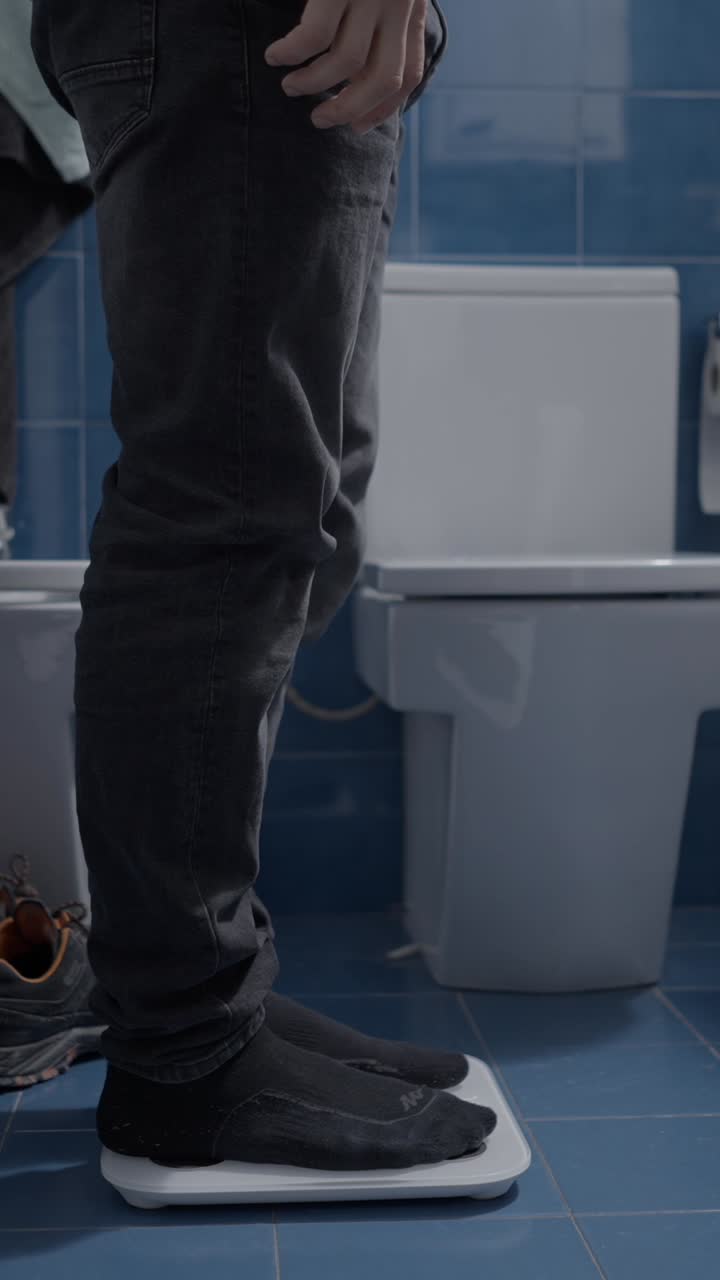 A person weighing themselves on a bathroom scale