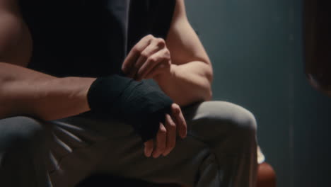 man putting on boxing wraps