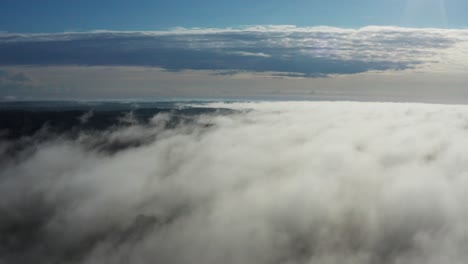 aerial forward motion above dense white cloud bed over land, latvia