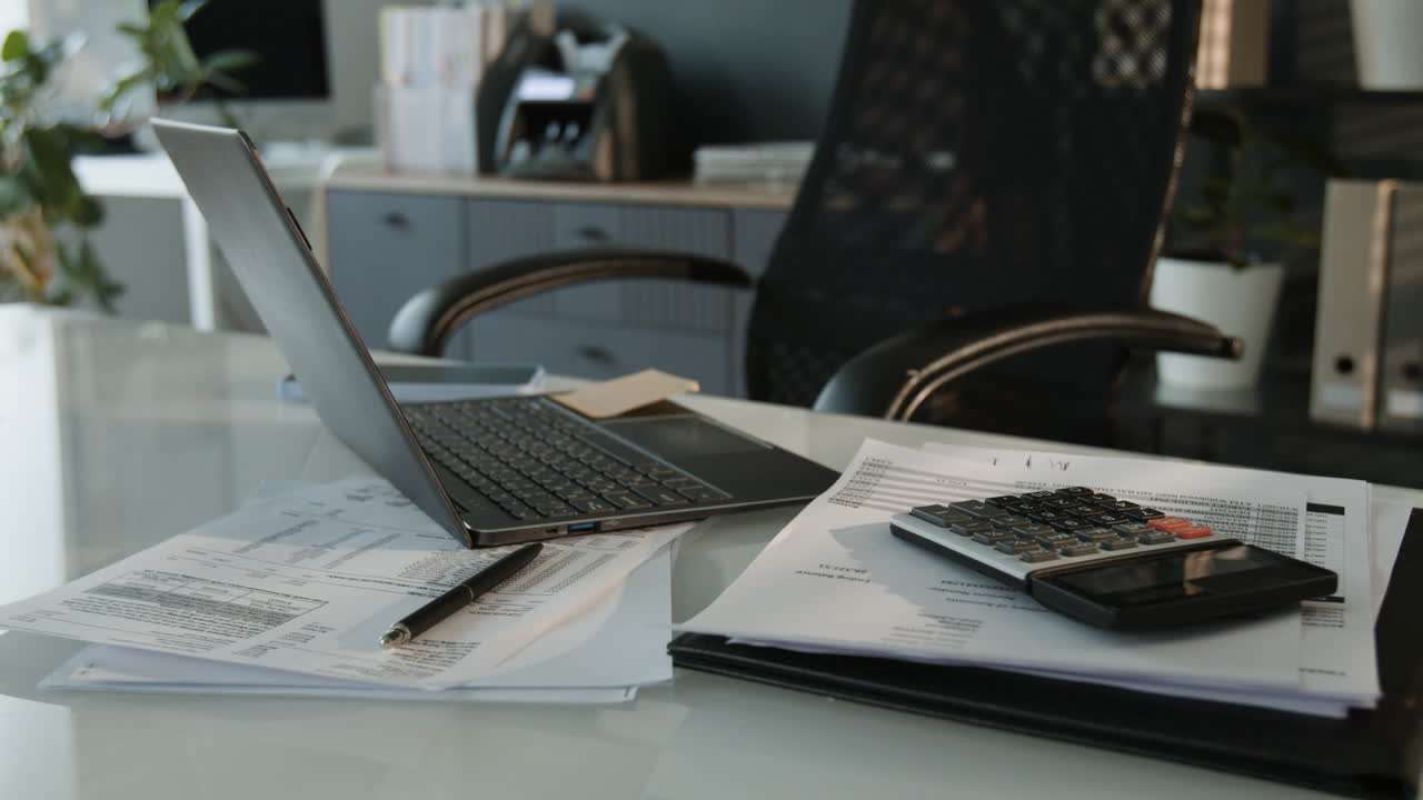 Modern Office Desk with Laptop, Calculator, and Financial Documents