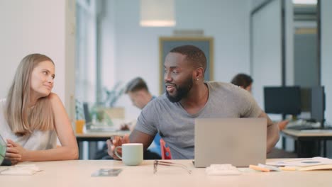 business man sleeping with laptop. smiling woman giving coffee to colleague.