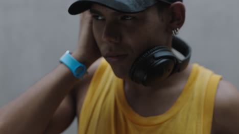 close up portrait young happy mixed race man listening to music wearing headphones enjoying relaxing lifestyle