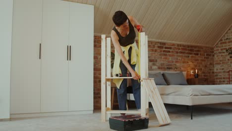 woman assembling wooden shelves in a bedroom