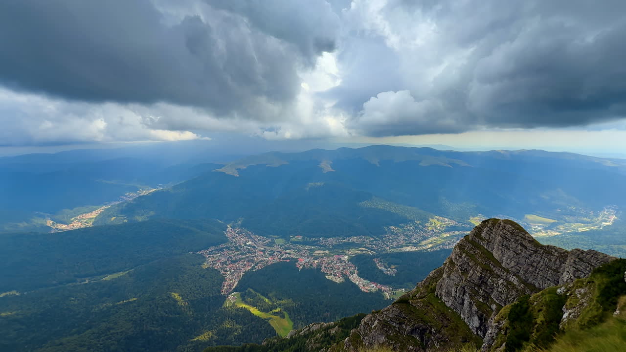 Aerial view of mountain valley and forest in Carpathians. Scenic panorama of town and forests surrounded by mountain ridges in the Carpathians