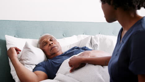 Krankenschwester-Besucht-älteren-Mann,-Der-Im-Bett-Liegt-Und-An-Depressionen-Leidet
