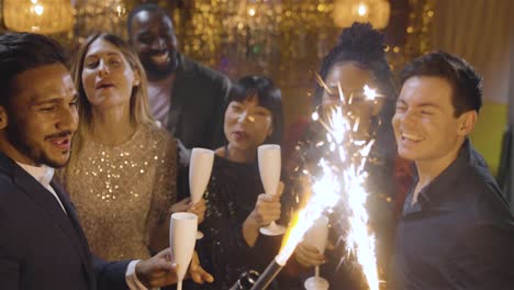 High-Angle-Shot-of-Group-of-Friends-Celebrating-New-Years-Eve-with-Champagne-Sparklers