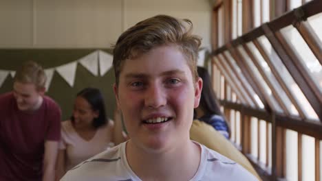 portrait of teenage boy in school classroom