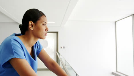 Thoughtful-nurse-standing-in-corridor