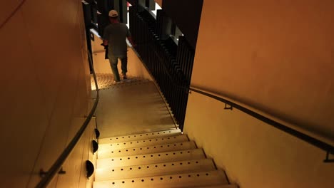 person walking down stairs in dim lighting