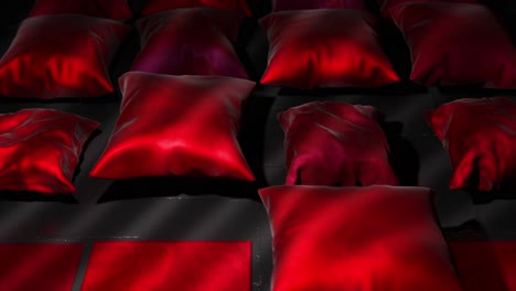 almohadas de satén rojo en superficie oscura