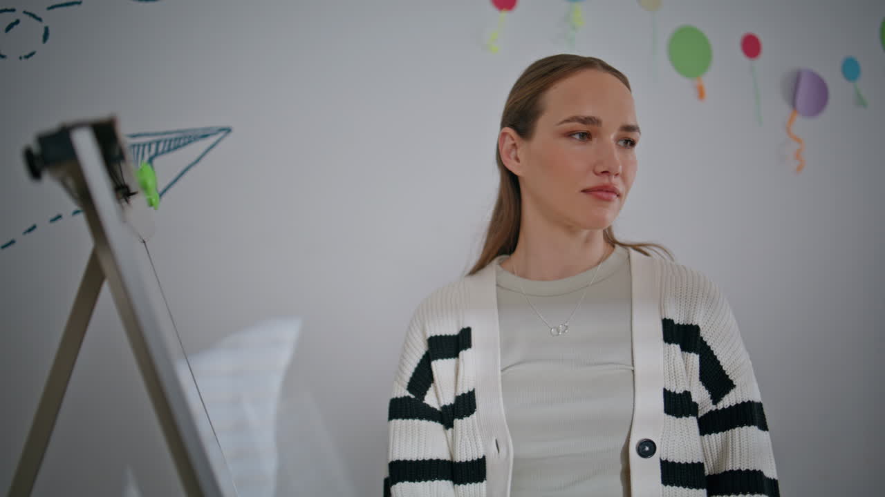 Talking schoolteacher standing whiteboard working at elementary school closeup