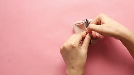 women hand open an empty wallet on pink background