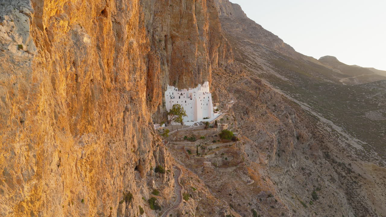 Holy Monastery of the Virgin Mary Chozoviotissa, The Panagia Hozoviotissa Monastery on steep cliffside at golden hour sunlight, Amorgos Island, Drone shot