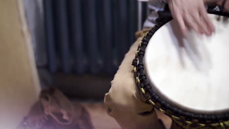 person playing a djembe drum