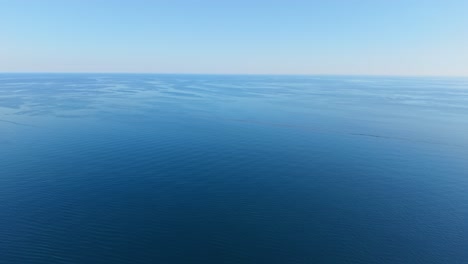 clear blue ocean with gentle waves, vast horizon, peaceful and serene atmosphere