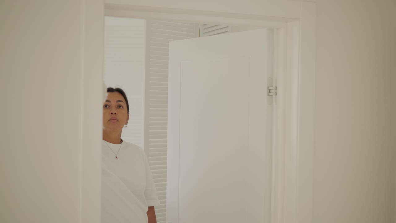 아름다운 임신한 여성이 집을 정리하고 집안일을 하고 있는 장면. 이 장면은 가정생활, 모성애, 그리고 임신 기간 동안의 일상과 준비의 균형을 담고 있다.