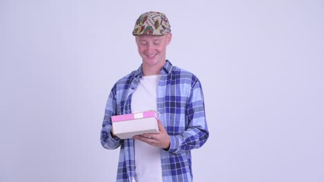 joven y guapo hombre hipster con una caja de regalos