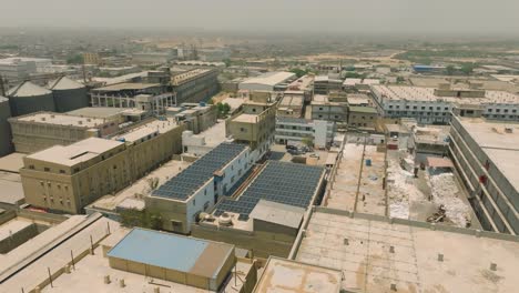 aerial view of a textile industry area with large buildings and solar panels, showcasing modern infrastructure and sustainable energy practices in an urban setting