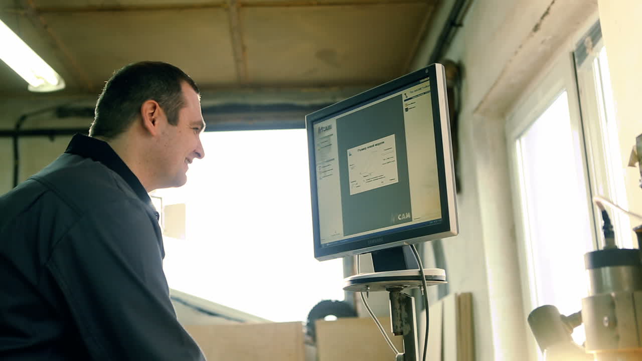 In the woodworkers shop the cnc drill is drilling on the wooden plank