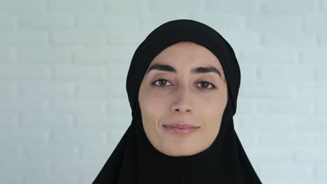 retrato de una mujer musulmana con un hijab negro sonriendo dulcemente y mirando a la cámara. la actitud del mundo hacia la religión musulmana, el derecho a la adoración es igual para todos
