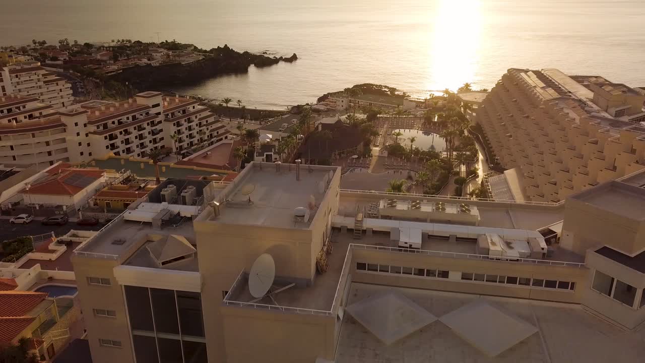 puesta de sol vista aérea de la isla de tenerife los gigantes arena playa drone volar sobre zona residencial con hotel y alojamiento listo para alquilar para vacaciones de verano