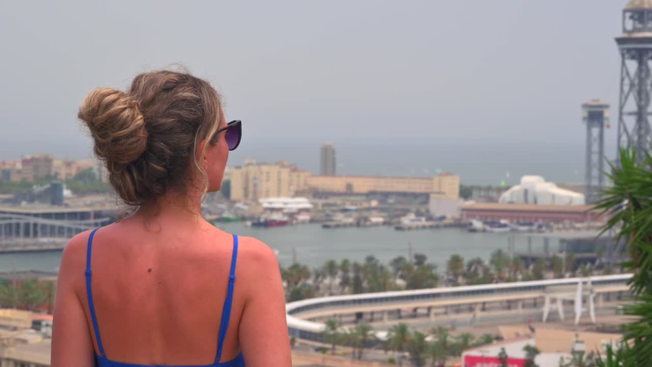 Woman in blue dress looking at the view of Barcelona, Spain