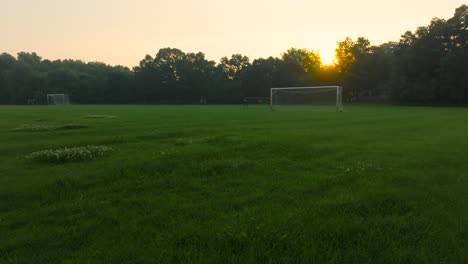 a morning sun rising over a soccer field