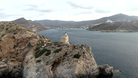 Drone-aerial-footage-of-flying-past-lighthouse-in-the-Mediterranean-on-the-island-of-Ios,-Greece