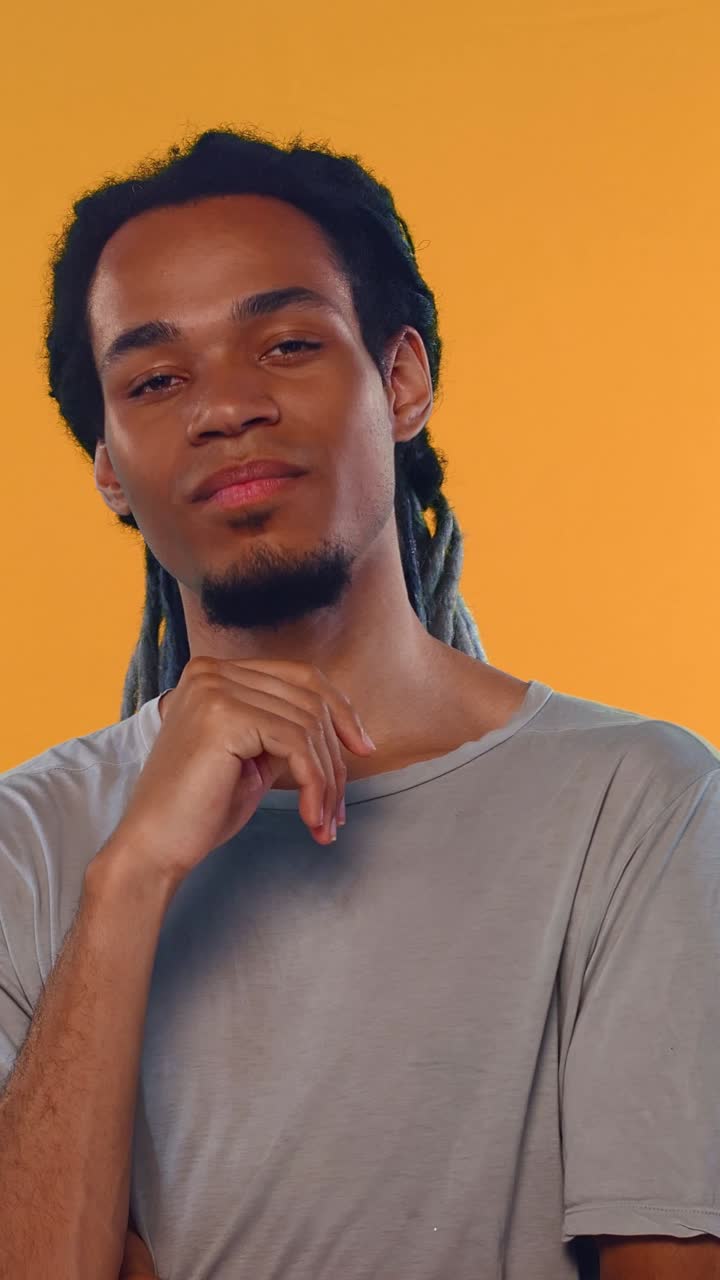 Thoughtful Young Man with Dreadlocks Looking at Camera
