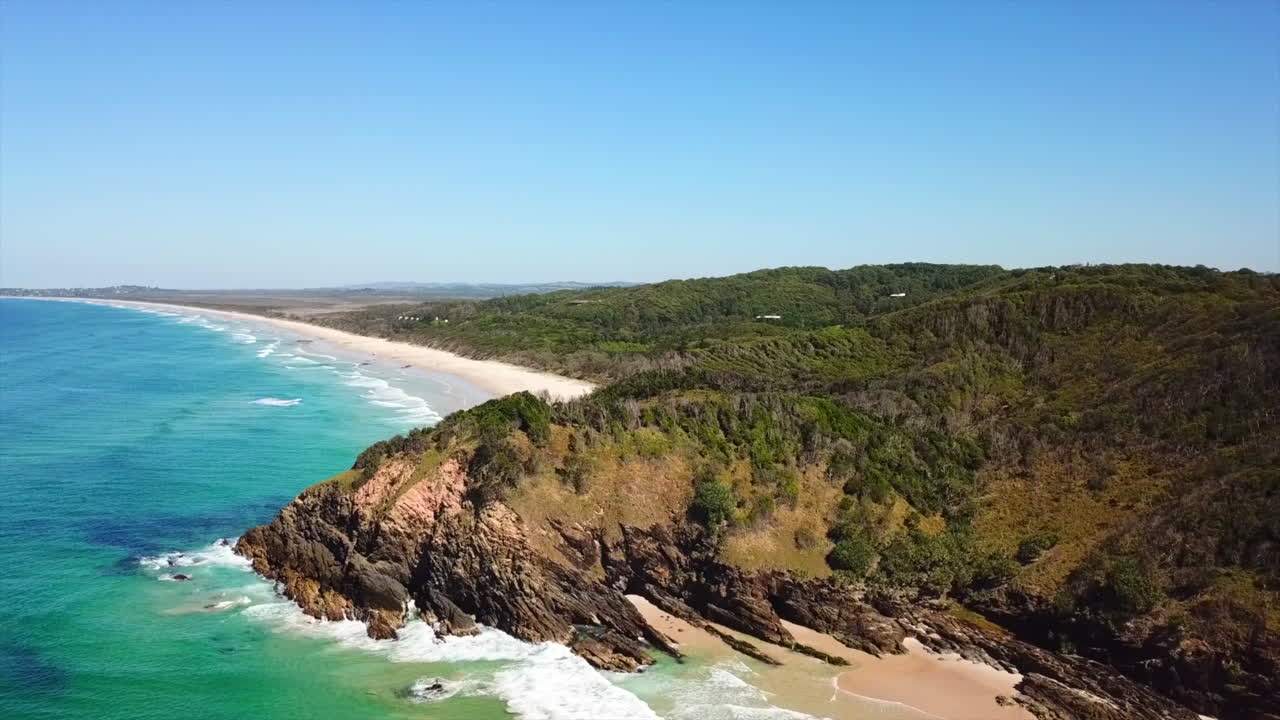 Aerea: Ripresa con drone che si eleva per rivelare una lunga costa di sabbia bianca vicino a Byron Bay, Australia.