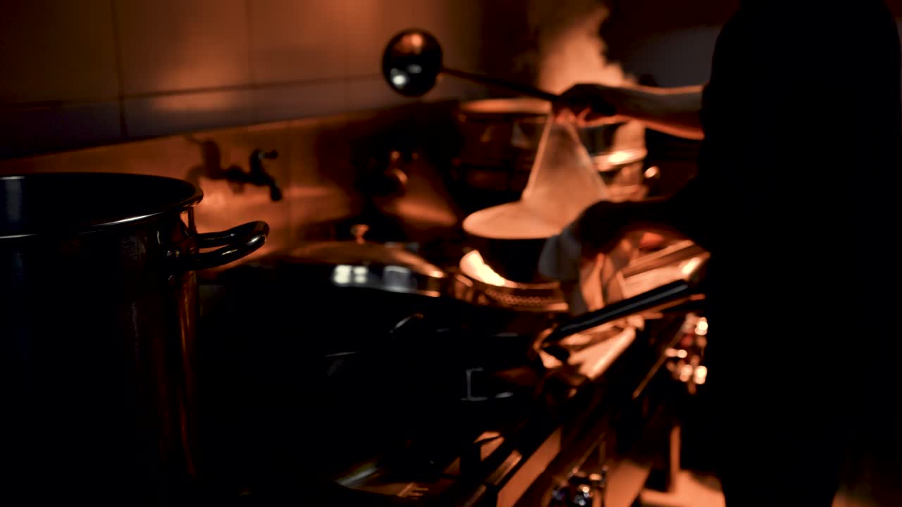 un chef cocinando en una cocina ocupada iluminación discreta en cámara lenta 4k