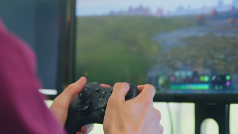 close up of man holding game controller playing shooting game online