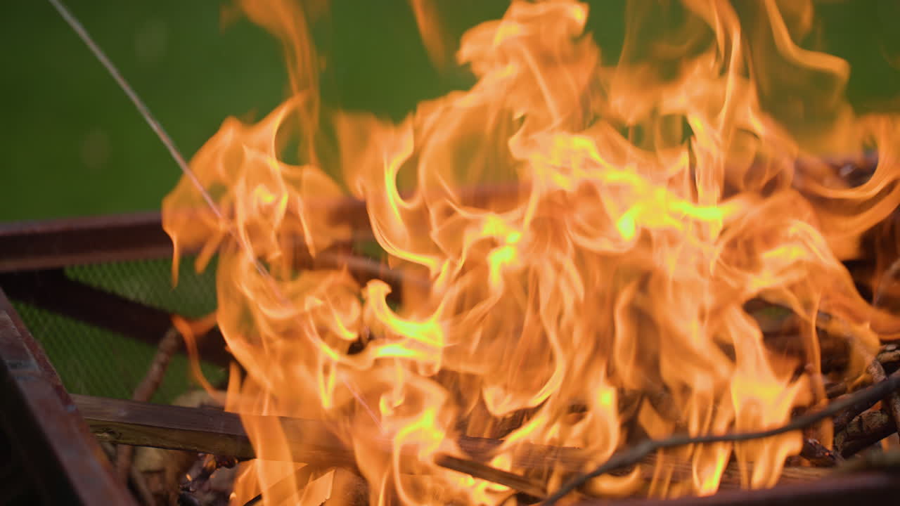 añadiendo líquido de encendedor a un pozo de fuego en cámara lenta