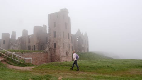 lady walker goes up steps to slains castle in the mist