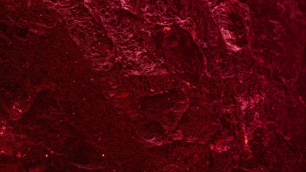 Shifting low light causing textured red surface showing subtle sheen and specks in macro close-up