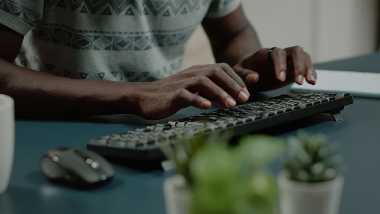 Close up of hands using computer keyboard and listening to music