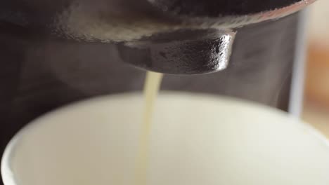 café caliente recién hecho saliendo de la foto macro de la máquina de café