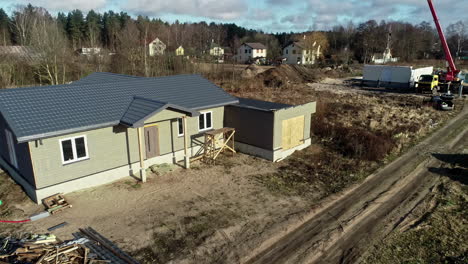 aerial drone rotates over prefabricated house built at new countryside neighbourhood