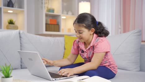 niña mirando la computadora portátil aplaudiendo.