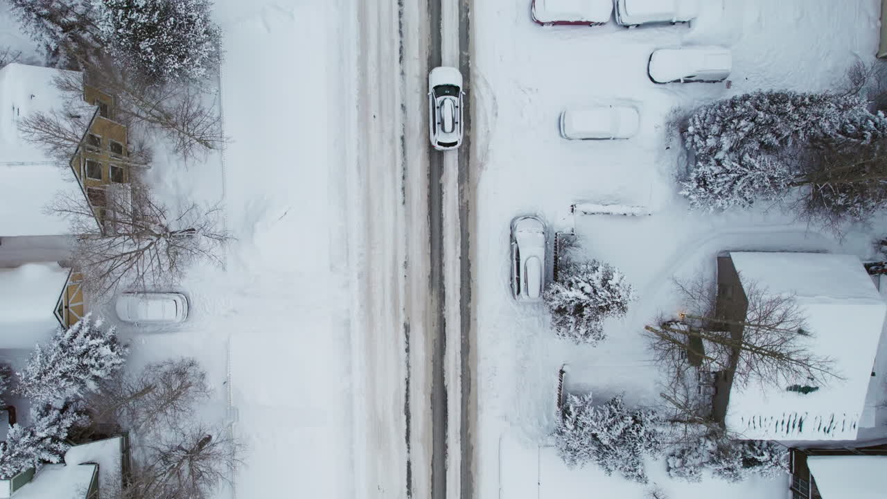 A center frame overhead of the main road through Breckenridge in winter, with cars driving through snow into the popular Colorado mountain town for a ski vacation at the world famous resort.