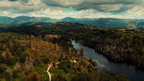 Clouds-rolling-over-mountains,-hills-and-lake-in-summer