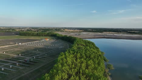 photovoltaic solar panel system under construction in scenic remote location between green narwal clean forest and calm still water lake