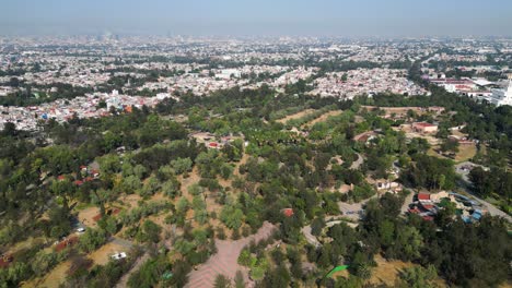 "la vida silvestre y el paisaje urbano: una vista de un avión no tripulado del bosque de san juan de aragón y la ciudad de méxico en la distancia