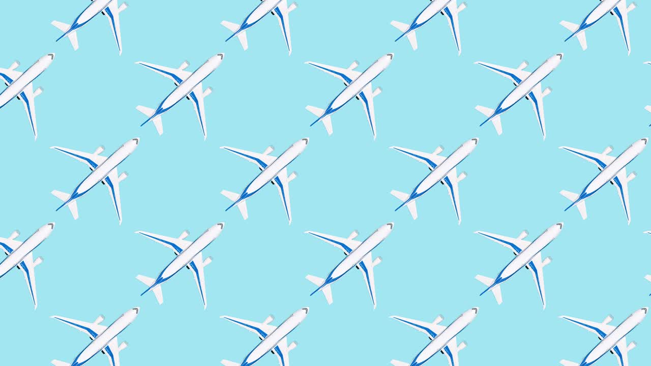 Pattern with white airplane moving on blue background. Repetitive travel stop motion animation. Toy plane from above. Travel and adventure concept, flat lay style