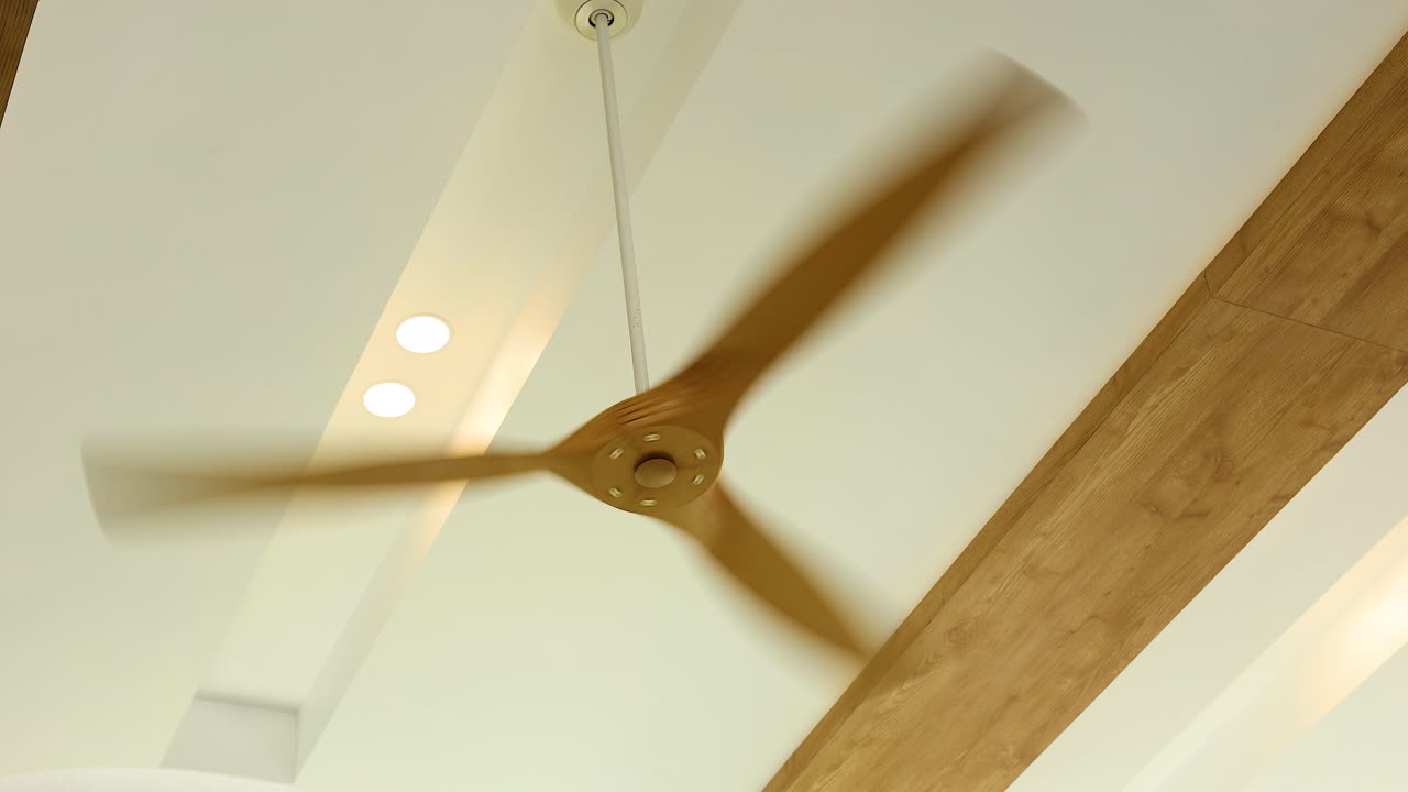 천장 팬 블레이드가 잘 조명 된 방에서 회전