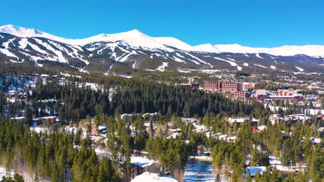 aerial drone view of hotels and appartments on ski resort in winter mountain town covered in snow with people skiing for holiday vacation in beautiful rental homes