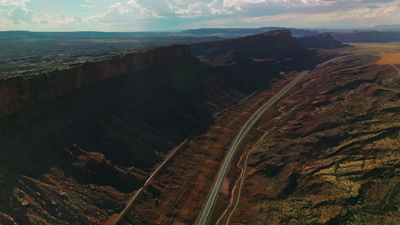 Motorways going through the land between the mountains. Wonderful desert landscape of Utah, USA from aerial view.